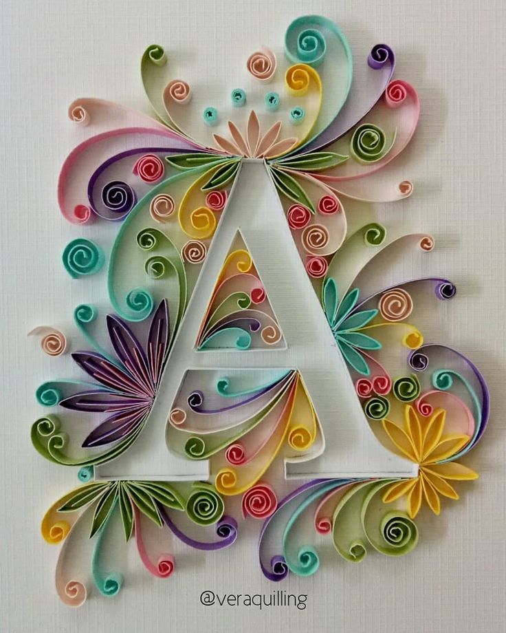 the letter a is made out of paper and has swirly spirals on it