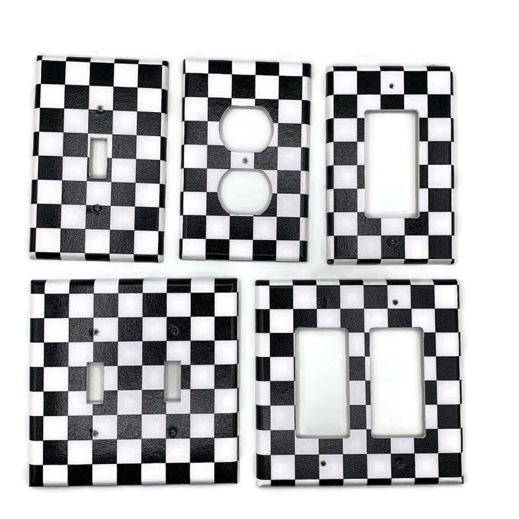 four black and white checkerboard switch plates with one light switch plate in the middle