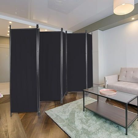 a living room with a couch, coffee table and black screen dividers in it