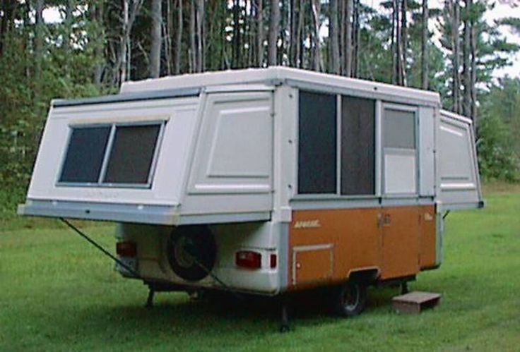 an old camper trailer is parked in the grass