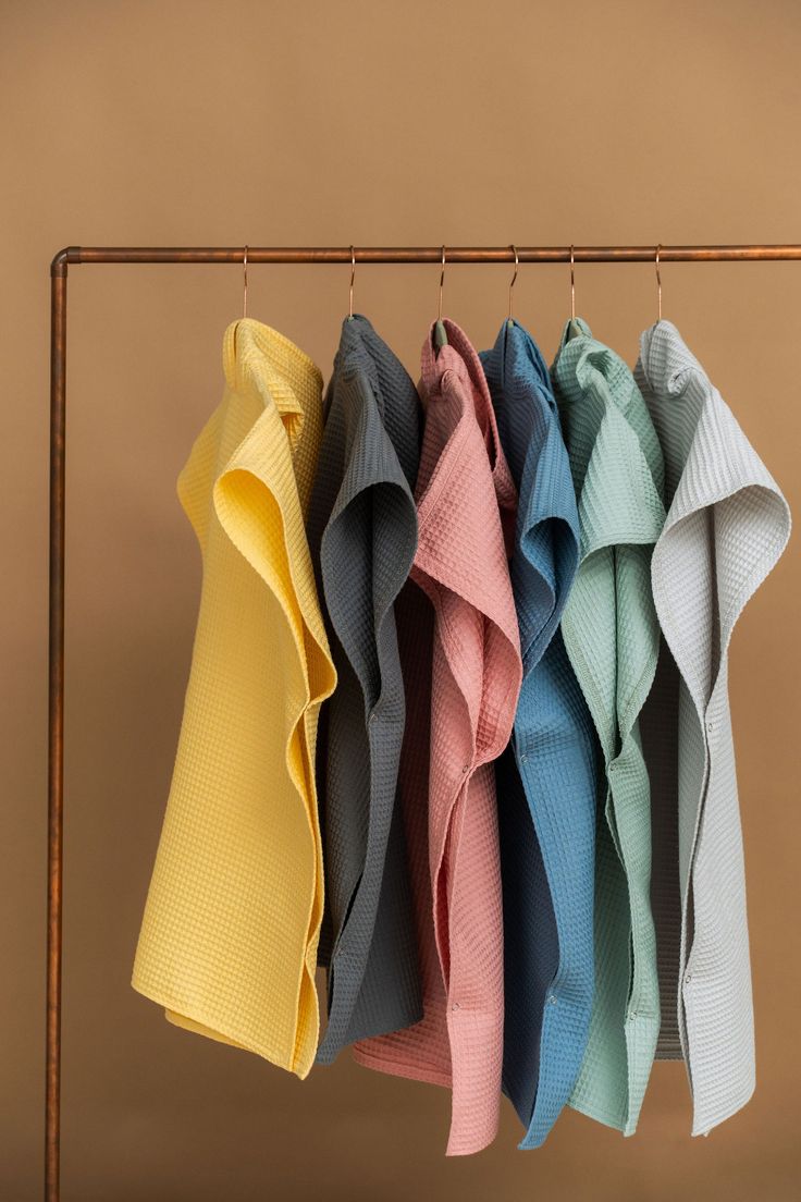 four folded towels hanging on a clothes rack