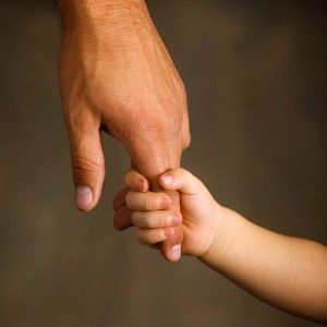 an adult holding the hand of a child's hand