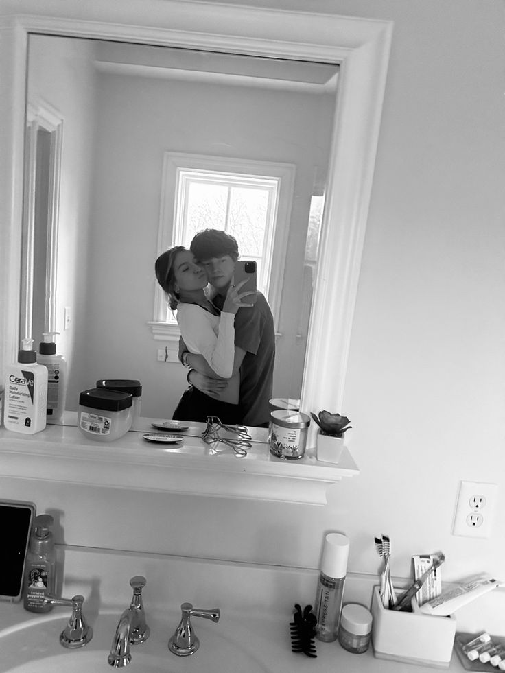 a man is taking a selfie in the bathroom mirror while holding his face to his chest