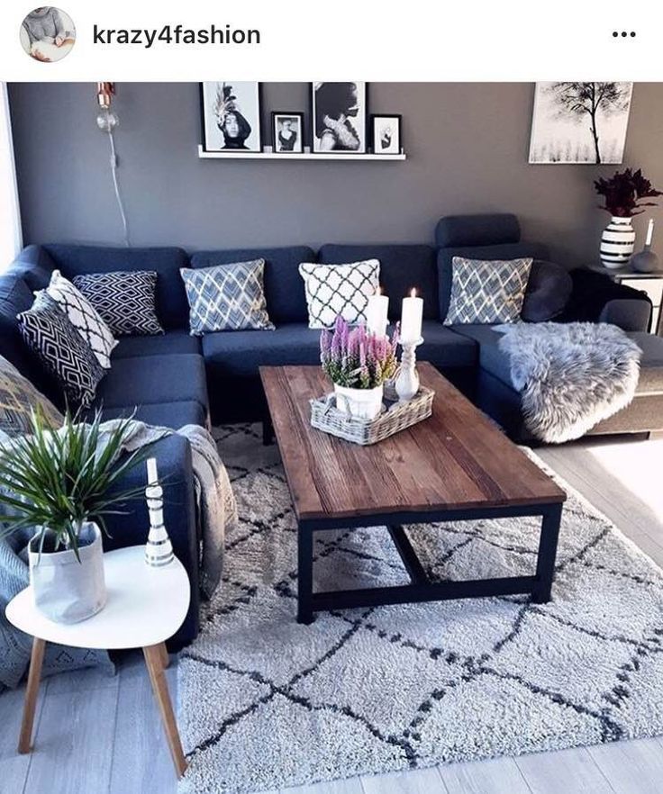 a living room with blue couches and pictures on the wall above them, along with a coffee table