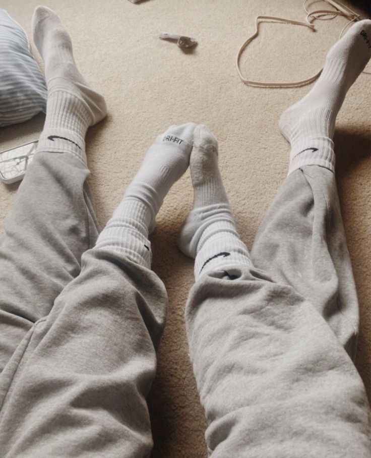 two people are laying on the floor with their feet up and one person is wearing socks