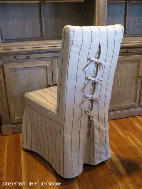 a striped chair with ties on it in front of a wooden cabinet and cupboards