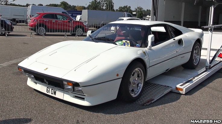 a white sports car being loaded onto a trailer