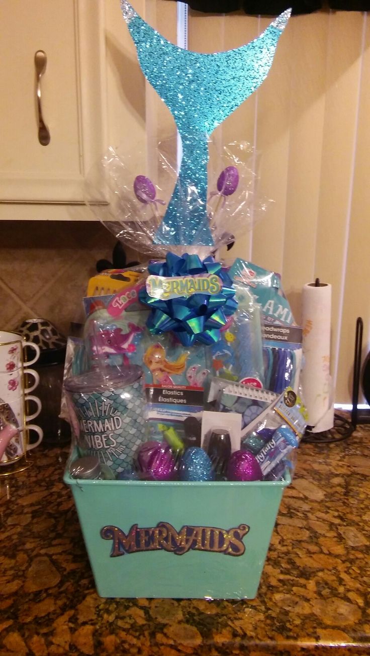 a mermaid themed gift basket with candy and candies on a countertop in a kitchen