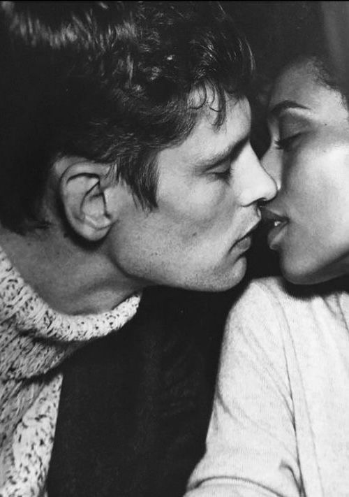 black and white photograph of two people kissing each other with their noses close to one another