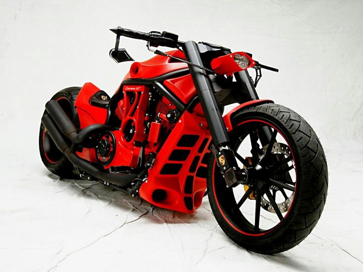 a red and black motorcycle parked on top of a white floor