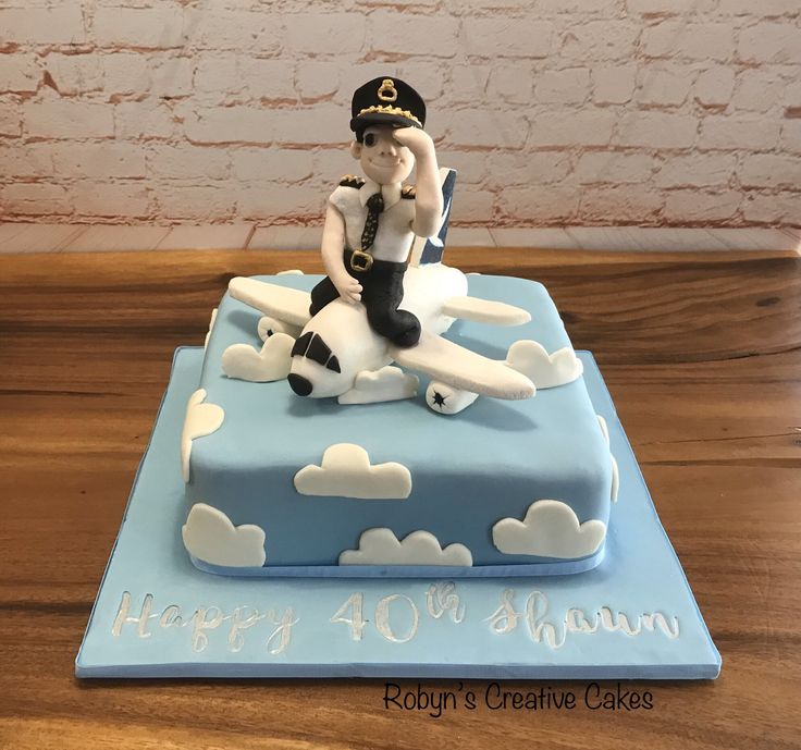 a birthday cake for a sailor on top of a blue and white plane with clouds