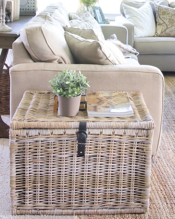 a living room with wicker furniture and plants on the coffee table in front of the couch