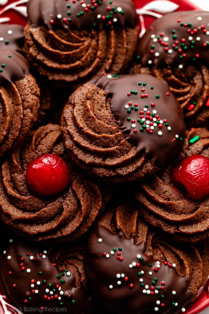 chocolate cookies decorated with candy and sprinkles on a red plate