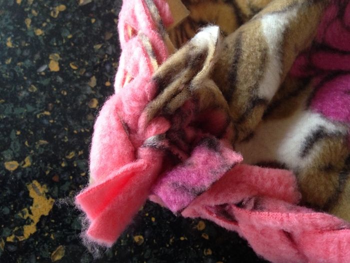 a pile of pink and brown blankets sitting on top of a floor