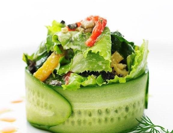 a salad with cucumber and tomatoes on it