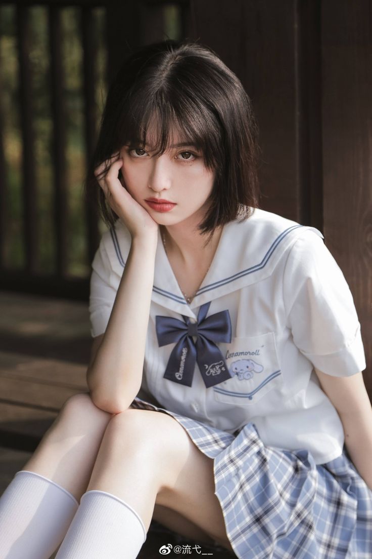 a young woman sitting on the ground with her legs crossed and wearing short white socks