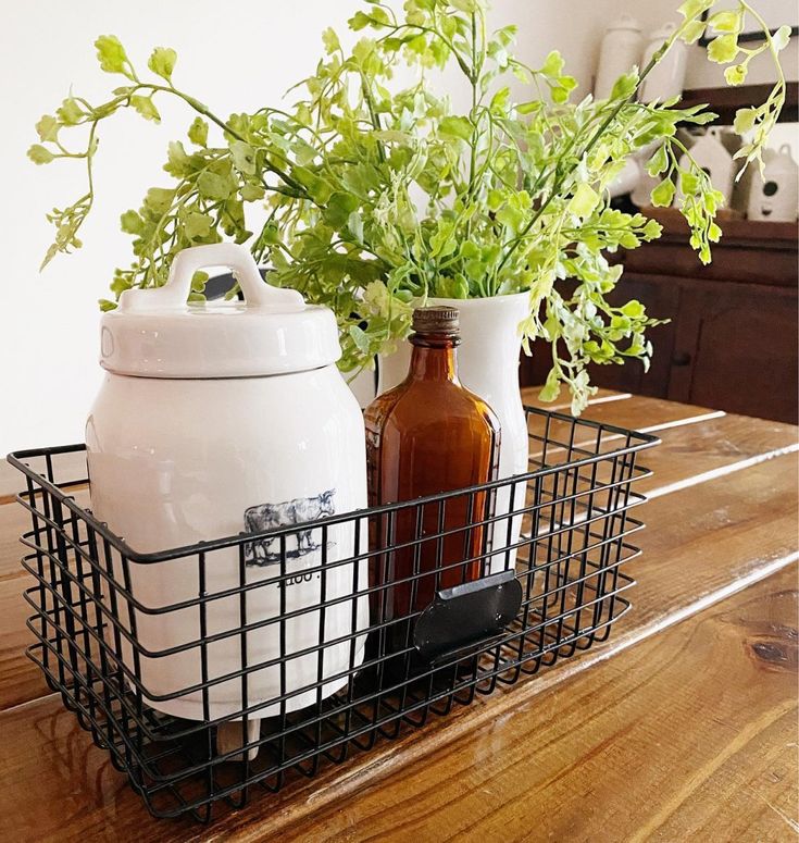 two jars with plants in them sitting on a table