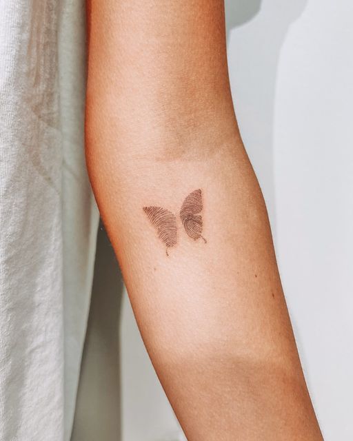 a woman's arm with a butterfly tattoo on the left side of her arm