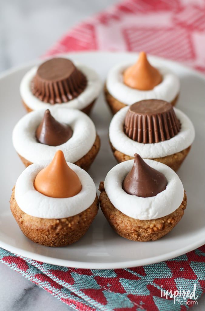 small cupcakes with chocolate and marshmallow toppings on a white plate