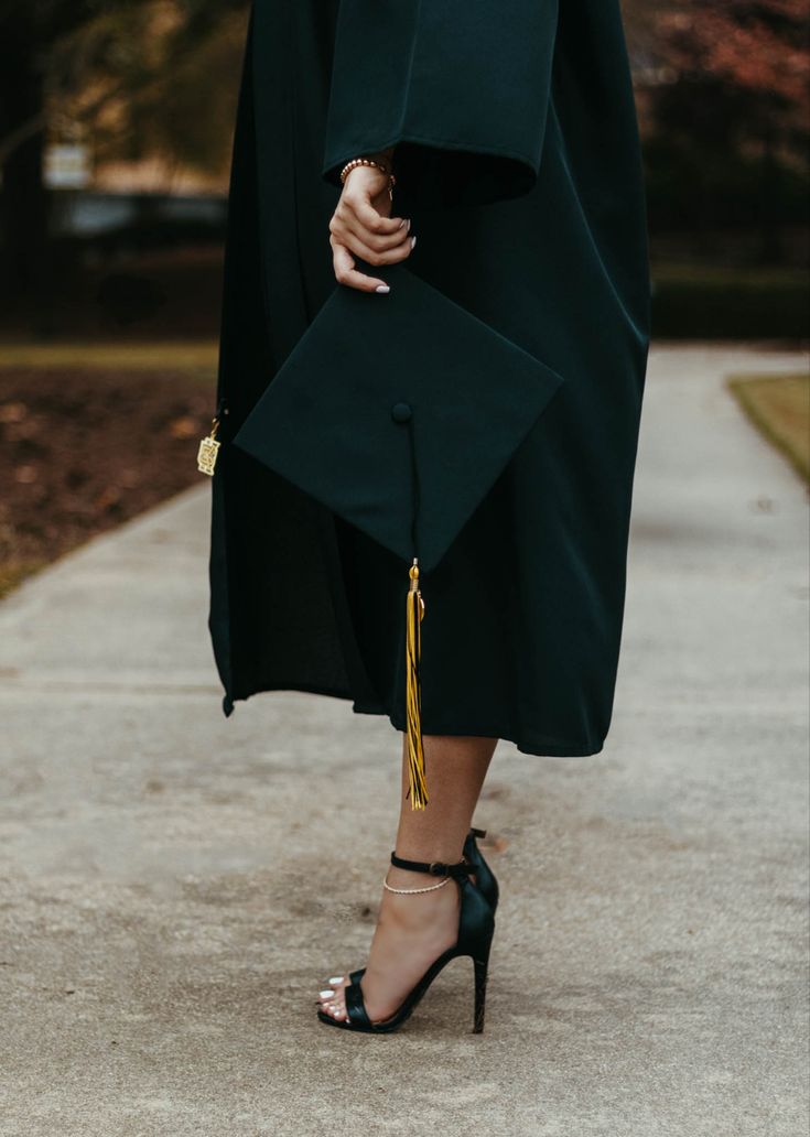 a woman in black graduation gown and high heels