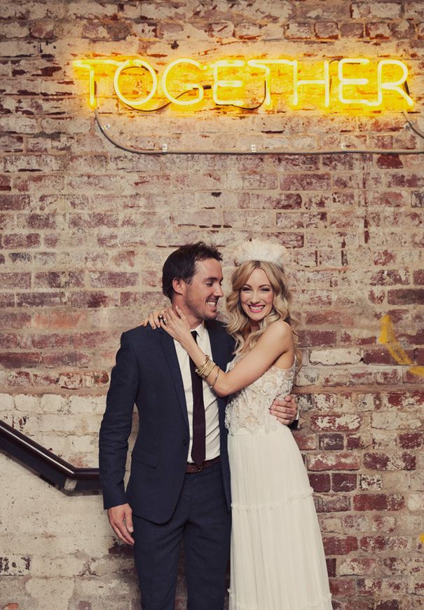 a man and woman standing next to each other in front of a sign that says together