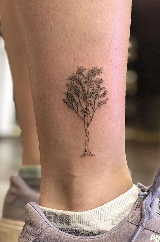 a small tree tattoo on the ankle