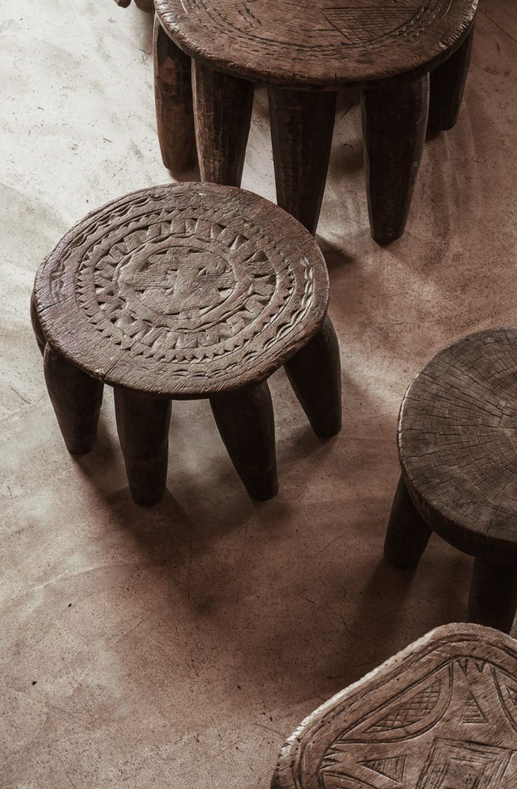 three wooden stools sitting next to each other