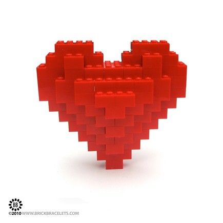 a red heart made out of legos on a white background with the words love spelled below it