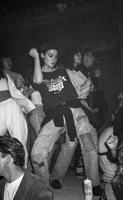 a group of people dancing in a dark room with one person on his back and the other