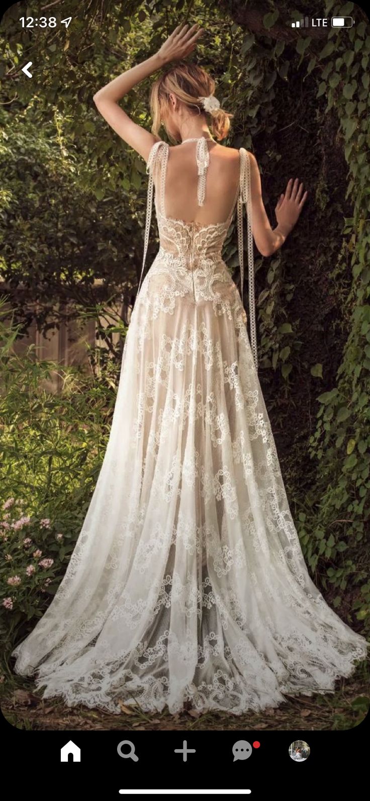 the back of a woman's wedding dress, with her hands on her head