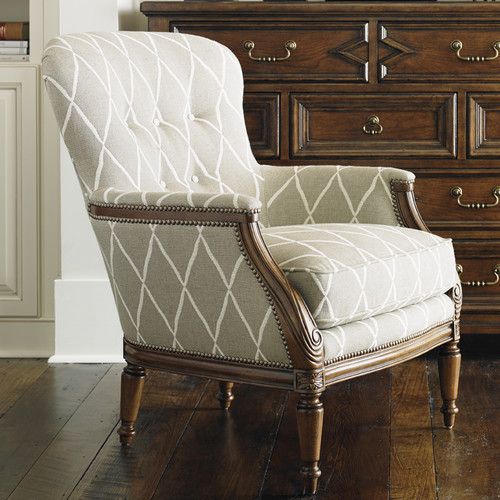 a white chair sitting in front of a wooden dresser