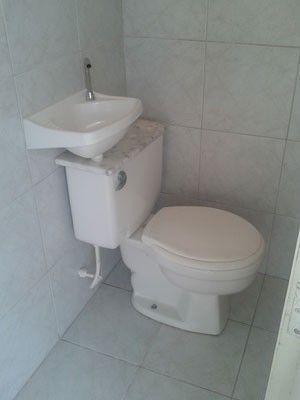 a white toilet sitting next to a sink in a bathroom