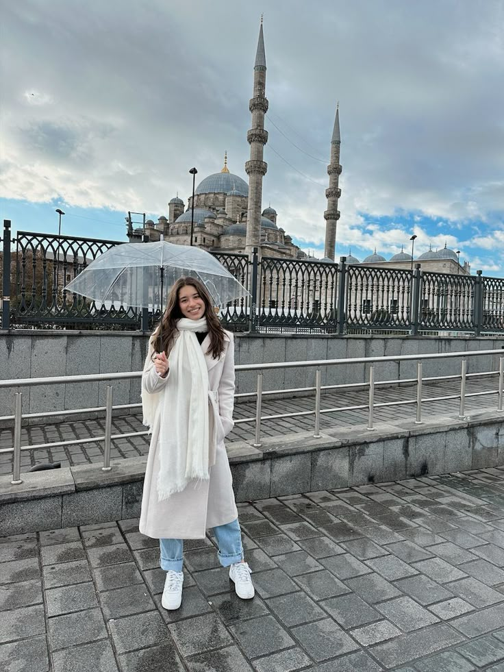 a woman is standing under an umbrella in front of the blue mosque, also known as the blue mosque