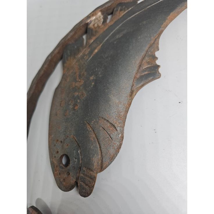 an old metal fish hanging on the wall