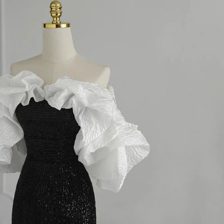 This gothic black and white wedding dress is sure to stand out from the rest. It is adorned with sequins and a ruffle that cascades down the front. The fit is flattering for all body types and the dress is sure to make a statement. ❤️CUSTOM MADE❤️ For custom made, please message us your height, bicep circumstance, bust, lower chest circumference, mid-shoulder to bust point, waist and shoulder width. How to measure? Black And White Prom Dresses, Masquerade Outfit, Black And White Gown, Dress Outfits Party, White Ruffle Dress, White Evening Gowns, Gowns Dresses Elegant, White Ball Gowns, Black Dress Formal