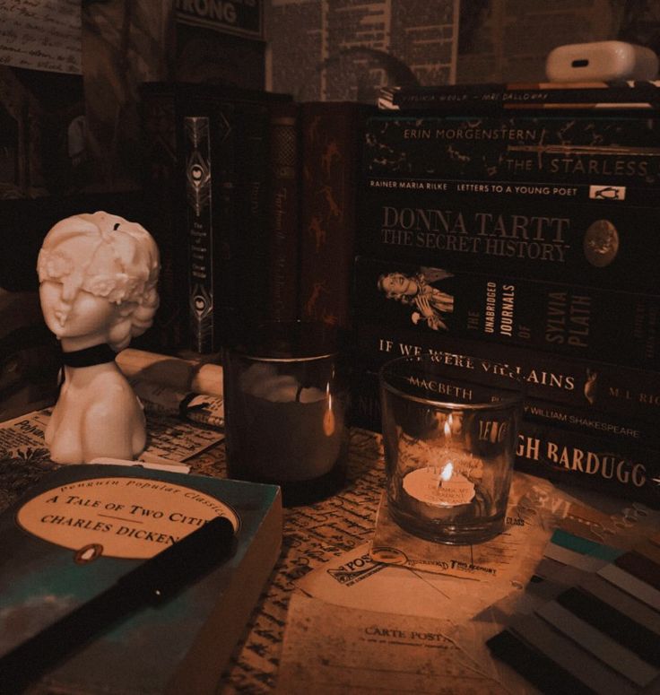 a table topped with books and candles on top of it