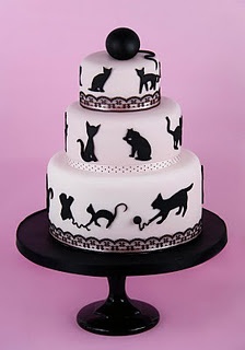 a three tiered cake with cats on it and a black cat design on the top