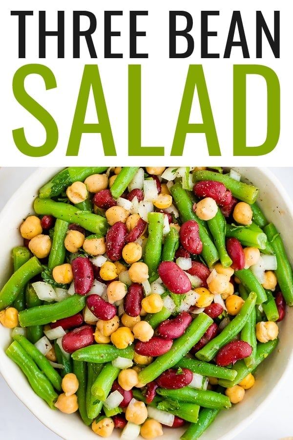 three bean salad in a white bowl with green beans and onions