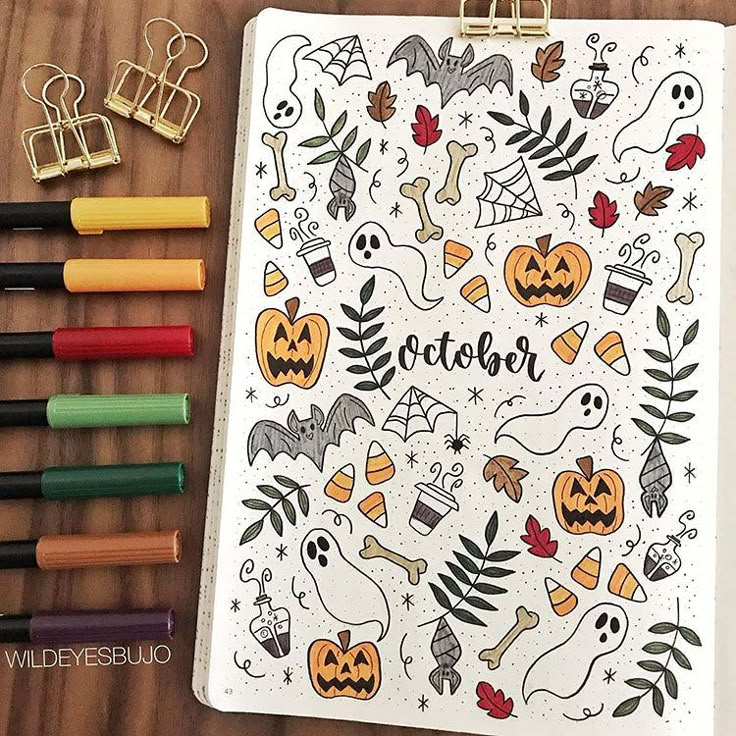 a halloween coloring book next to markers, crayons and colored pencils on a table