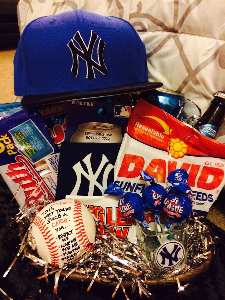 a new york yankees hat, baseball cap, candy and snacks in a gift basket