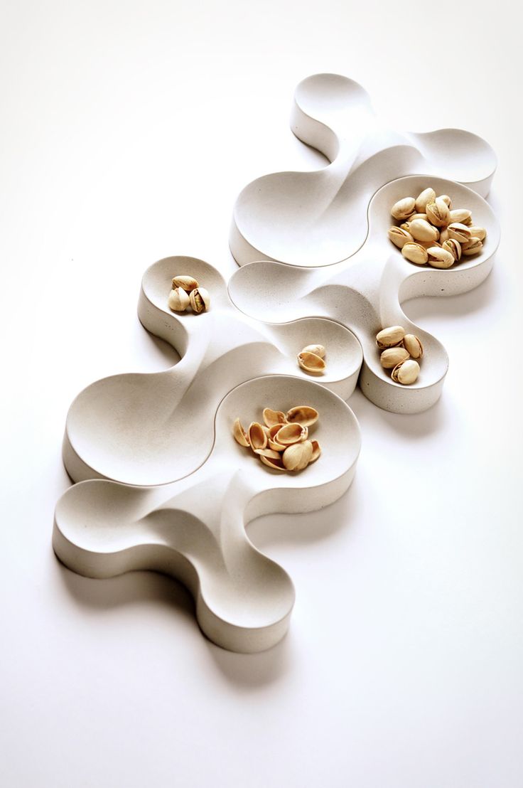 four bowls with nuts in them on a white surface, one is shaped like an octopus