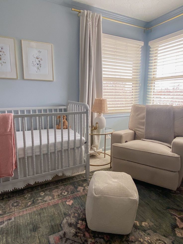 a baby's room with a crib, chair and ottoman