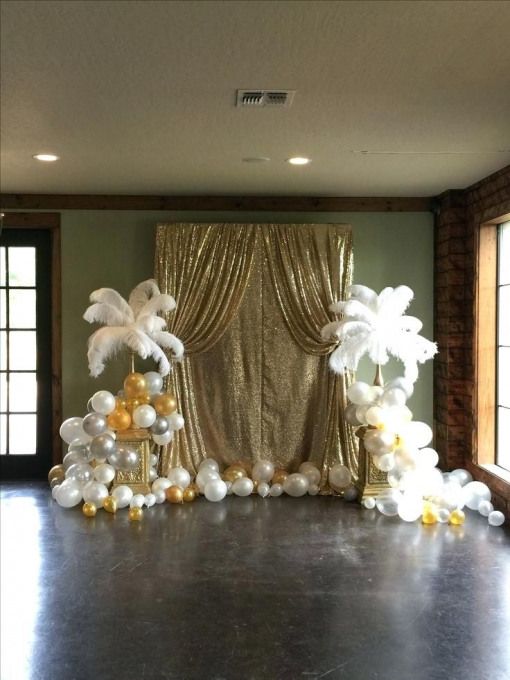 a large room with balloons and decorations on the floor in front of a gold curtain