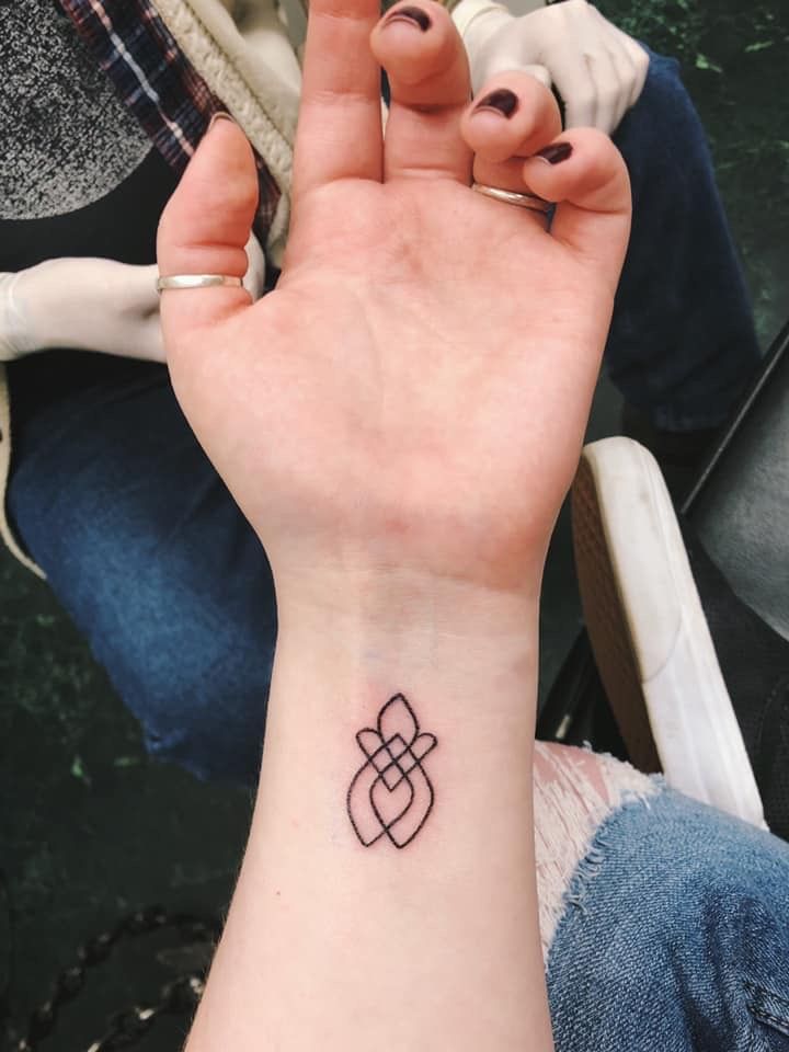 a woman's hand with a small tattoo on it