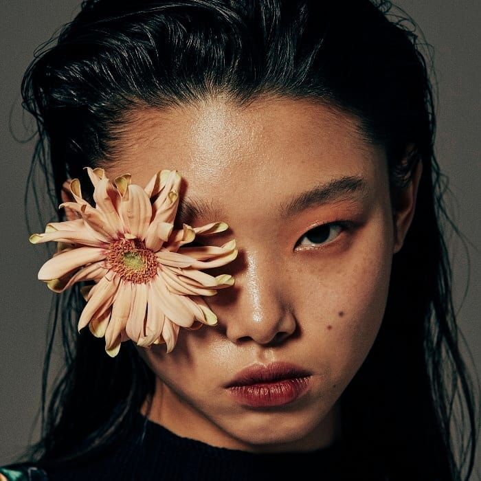 a woman with a flower in her hand and the image is made up of black and white