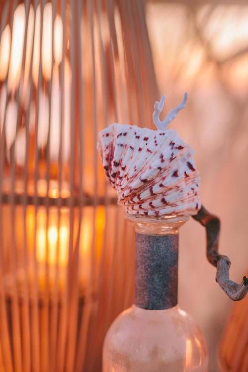 a bottle with some kind of whipped cream in it next to a wicker lamp