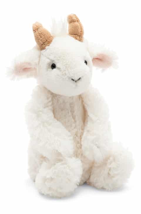 a white stuffed animal with horns on it's head and legs, sitting against a white background