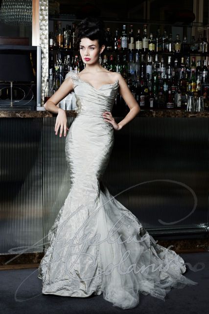 a woman standing in front of a bar wearing a dress with ruffles on it