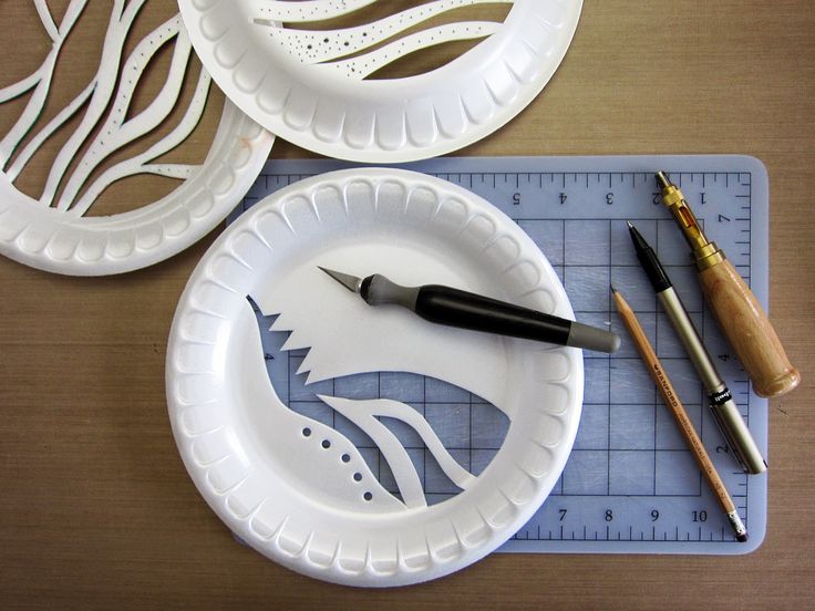 some paper plates are sitting on a table with scissors and pencils next to them