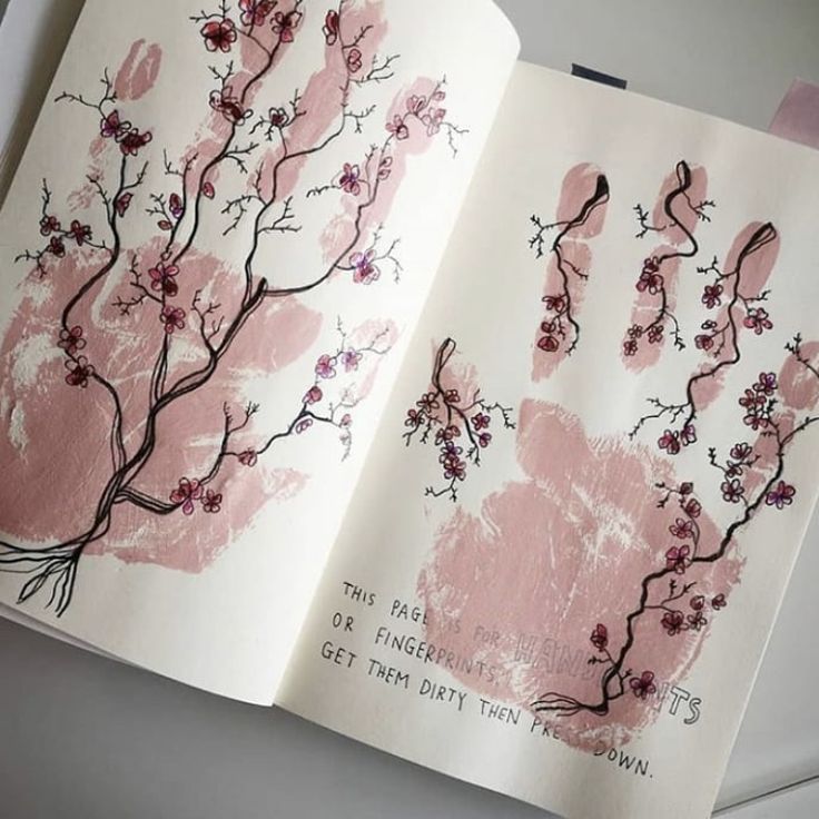 an open book with pink hand prints on it